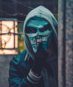 Dealing With The Imposter Syndrome - Second Image on Blog of a Man in a Mask with a silence Finger pointed to his face.